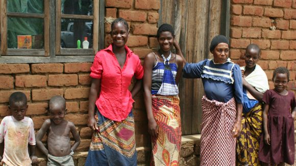 Agnes stands with her family and smiles.