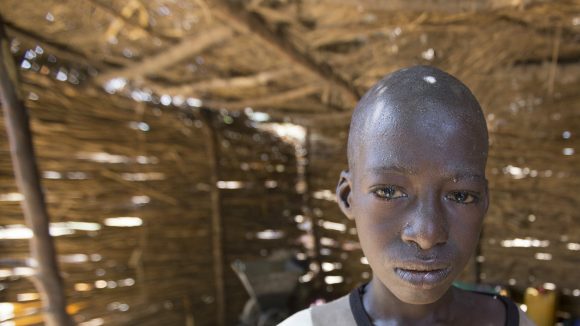 Abdu stands in his house.