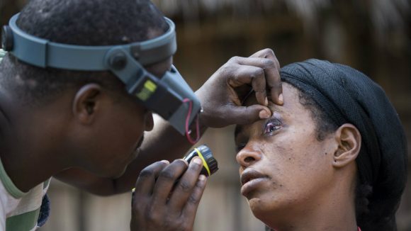 Hibret's eyes are checked by a health official.