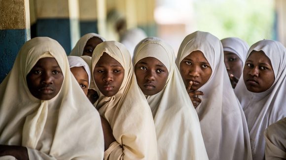 Elever på Jongowe-skolan köar tålmodigt i väntan på ögonundersökning. Man kan till exempel identifiera synfel.