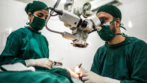 Ett kirurgiteam utför en gråstarroperation.
