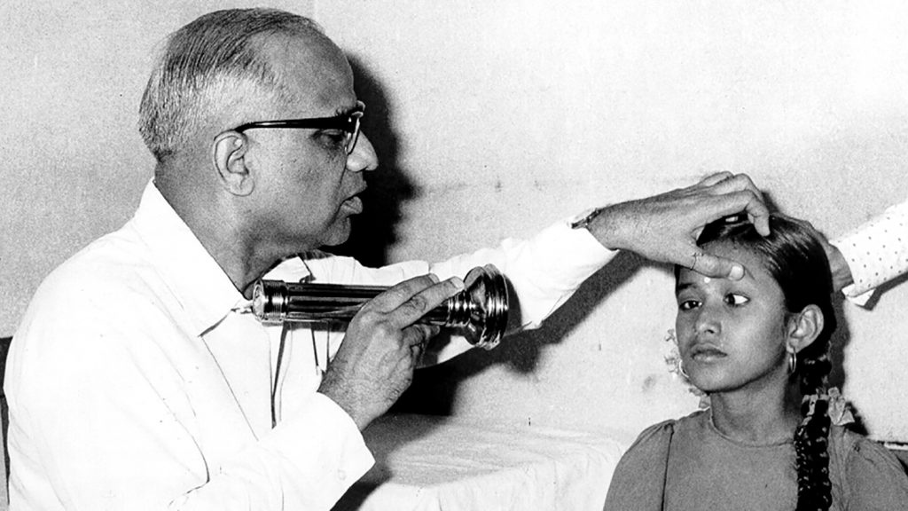 En läkare undersöker ögonen på en flicka i Indien på 50-talet.
