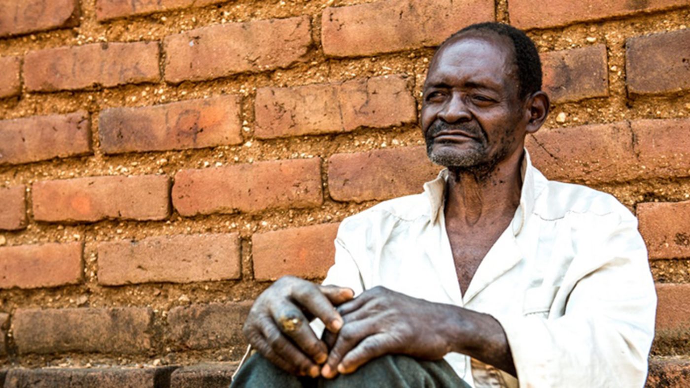 Mr Winesi har bilateral grå starr. Han sitter utanför sitt hus i Mwanza-distriktet.