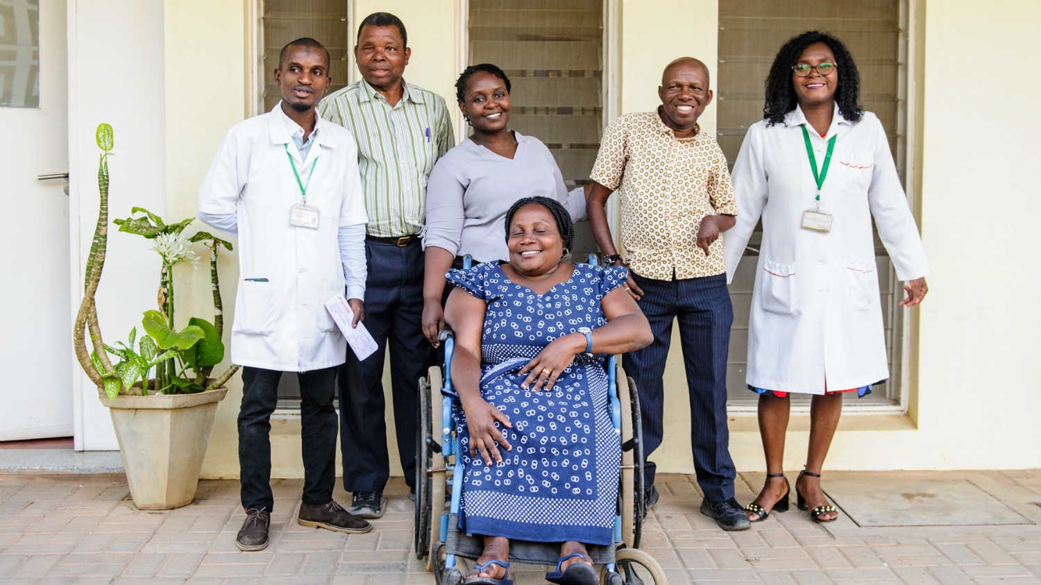 Ledare för organisationer för personer med funktionsnedsättning, personal från Sightsavers och läkare tillsammans med Camilo Morreira utanför ett sjukhus.