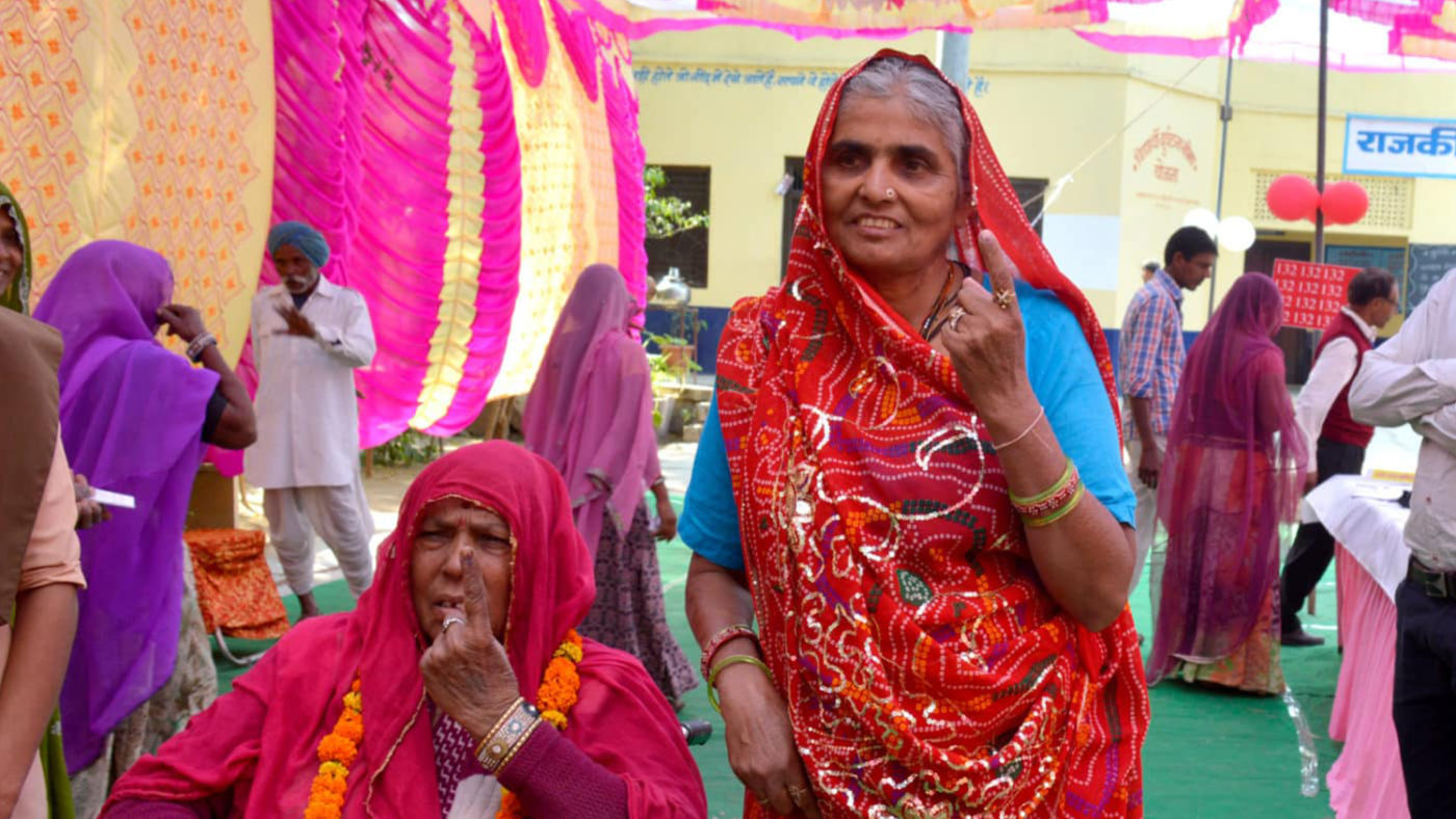Två kvinnor visar sina pekfingrar efter att ha röstat i Indiens allmänna val 2019.