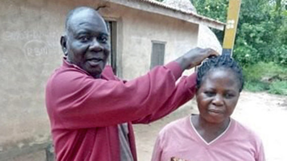 Emmanuel Nyamkeen measures a woman's height to determine how much medication to give her.