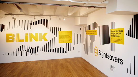 Sightsavers utställning BLINK i London med BLINK-logga och Sightsavers-logga.