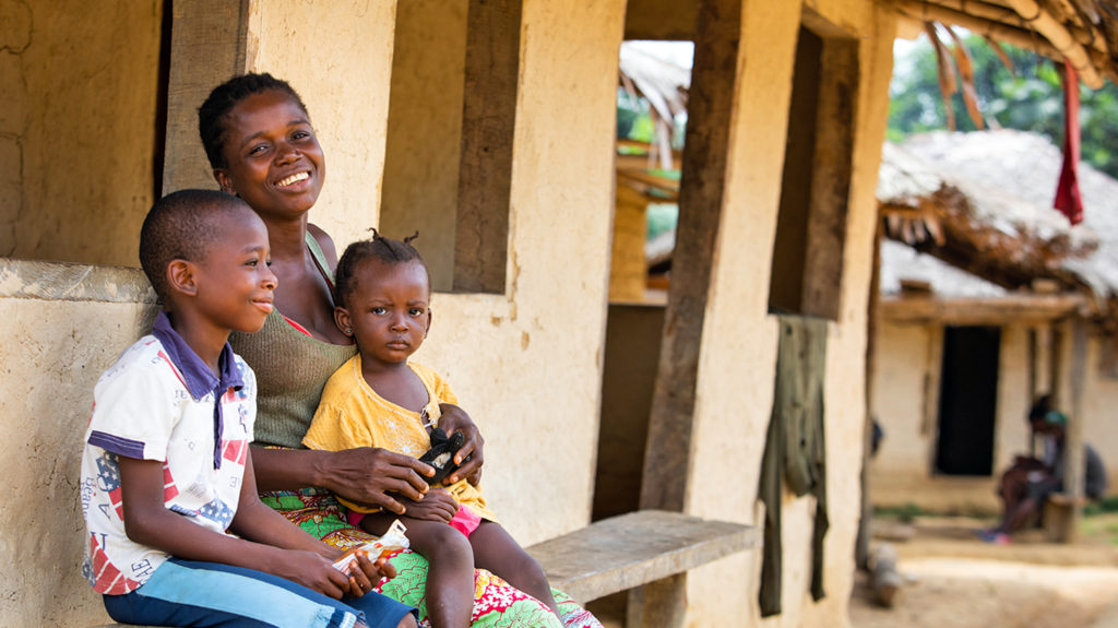 Sia och hennes barn ler efter en ögonundersökning i Liberia.