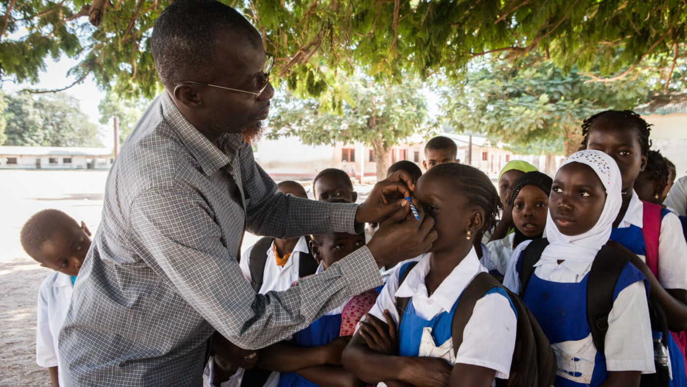 En sjukvårdare undersöker ögonen på barn för symtom på trakom.