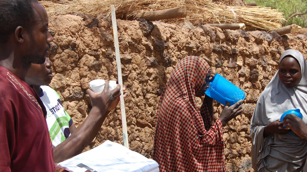En kvinna dricker ur en bägare efter att ha tagit medicin i Nigeria.