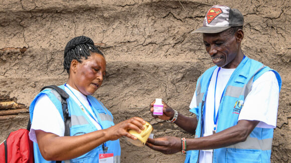 Samhällsvolontärerna James och Elizabeth förbereder medicin för distribution i Kenya.