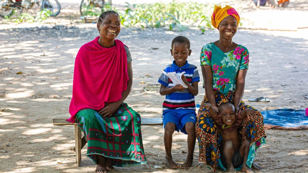 Mohamed sitter utomhus med sin familj. De ler och skrattar alla tillsammans.